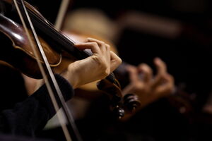 Bühnenangst und Auftrittsangst überwinden und entspannt auftreten Eine Geigerin spielt auf ihrem Instrument. Im Hintergrund ist eine weitere Geige zu sehen. Bühnenangst und Auftrittsangst kann überwunden werden. Entspanntes Musizieren ist möglich.