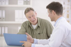 Zwei Männer unterhalten sich. Der eine schaut ängstlich, während der andere, ein Coach oder Psychotherapeut ihm erläutert, wie seine Ängste überwunden werden können.
